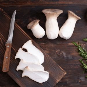 cooking with king oyster mushrooms on a chopping block